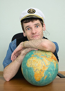 年轻人在船长的帽子与地球图片