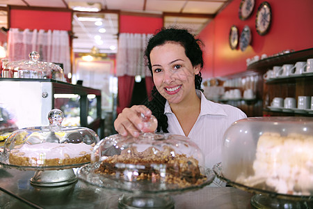 一家小商铺的老板 展示她美味的蛋糕业主咖啡店员工零售相机工作食堂杂货店熟食中年图片
