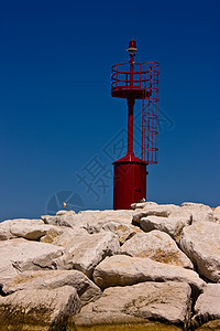 海岸上的红灯危险蓝色灯塔导航照明岩石沿海天空安全海洋图片