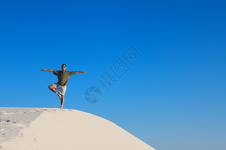 穿红衬衣的男子 手举起在瑜伽树上图片