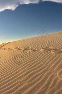 沙丘中的脚印地形太阳蓝色时间旅行孤独橙子波纹日落风景图片