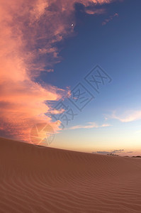 沙漠中的日落闪耀风景脚印时间假期爬坡橙子天空波纹沙丘太阳图片