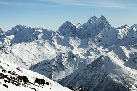 在多云天气下雪的山中旅游太阳远足阳光爬坡天空晴天季节蓝色旅行图片