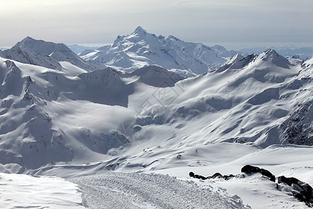 在多云天气下雪的山中太阳旅游冻结爬坡登山季节旅行山峰阳光闲暇图片