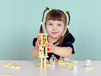儿童在餐桌上玩小玩具游戏孩子裙子骨牌女孩柜台白色骨头童年蓝色图片