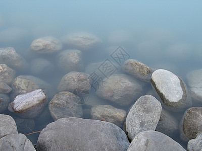 灰色抛光岩石和绿河水石头扣篮反射绿色蓝色图片