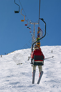 滑雪电梯滑雪者阳光爬坡行动运输运动椅子活动闲暇缆车图片