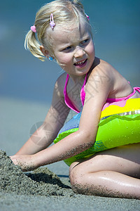 海滩上的女孩波浪孩子天空蓝色海洋乐趣晴天头发玩具童年图片