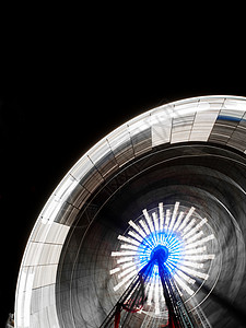 夜间摩轮轮喜悦蓝色运动旋转速度闲暇马戏团车轮圆圈公园图片