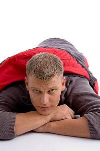 青年男子用红色睡袋盖住自己成人男人幸福地面休息说谎双臂白色衣服闲暇图片