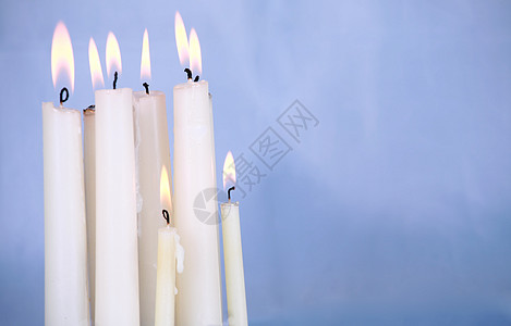 在蓝色背景下燃烧的蜡烛图片