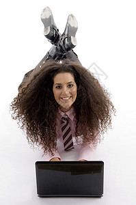 用笔记本电脑躺着的年轻聪明女商务人士图片
