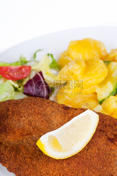盘子上的雪梨肉排的细细细节土豆胡椒叶子猪肉薯条面包屑柠檬油炸黄色午餐图片