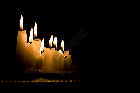 一群在黑暗中燃烧的白色蜡烛团体灯芯图片