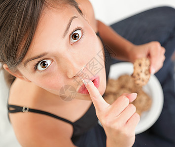 女人吃饼干蛋糕秘密眼睛零食食物饮食甜点女孩们小吃芯片图片