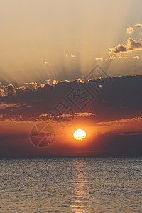 日落在平静的水面上天空红色圆形黄色海洋热带金子旅行太阳海滩图片