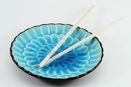 蓝板上的筷子木头盘子装饰文化蓝色情调传统异国风格风俗图片