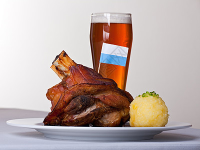 盘子上加土豆的猪肉传统皮肤菜式饺子餐厅肉汁旗帜美味蓝色桌布图片