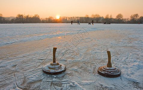 日落时在冰冻的湖边两块圆石划痕娱乐运动游戏石头行动团队活动图片
