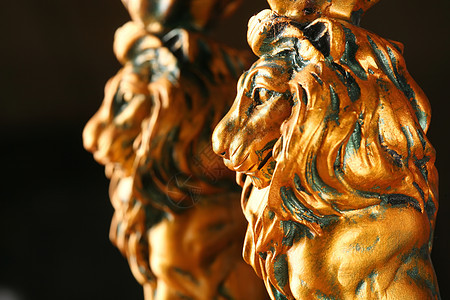 两只金狮动物雕塑鼻子黑色黄色眼睛鬃毛背景图片