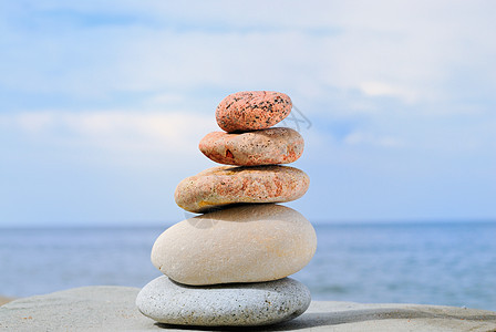 温暖的石头海滩沉思巨石天空鹅卵石蓝色冥想岩石平衡阳光图片