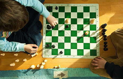 男孩在地板上下象棋背景图片