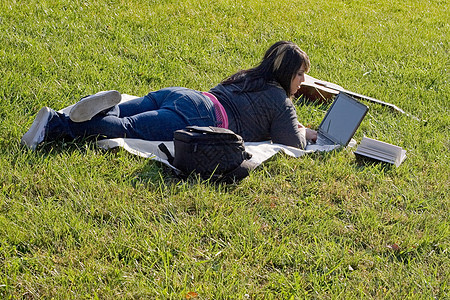 女孩使用笔记本电脑大学写作家庭作业黑发冲浪女性青少年学生校园毯子图片
