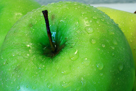 绿色苹果与水滴的特写图片