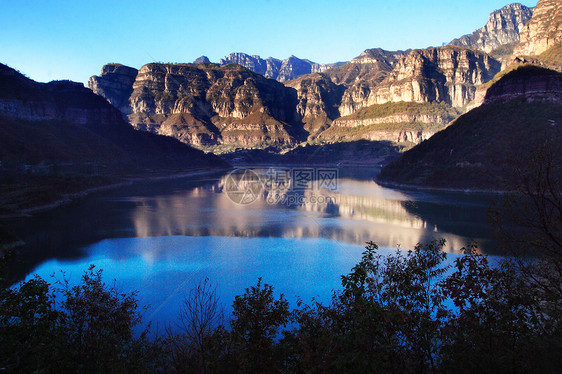 自然 风景 旅行岩石村庄金子山脉红色太阳河流绿水树叶反射图片