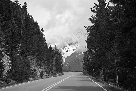 驾车进入多云的山岳背景模板树木丘陵山脉演示街道文稿图片