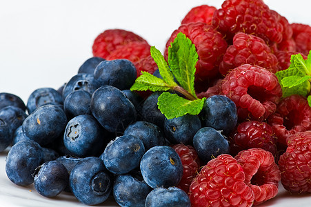 蓝莓和有薄荷叶的草莓香料甜点食物盘子蓝色草本植物绿色覆盆子红色白色图片