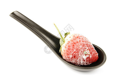 黑勺子上的冷冻草莓热带甜点水果饮食黑色绿色食物小吃白色红色图片