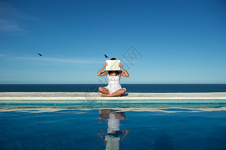 放松阅读游泳池假期享受反射幸福海滩活动蓝色天空女性图片