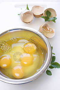 金属碗中的鸡蛋和叶子图片
