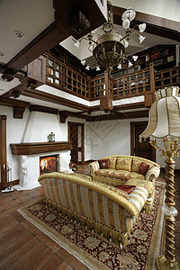 带有壁炉和楼梯的客厅内栏杆地毯大厅木头沙发扶手桌子文化电视平板图片