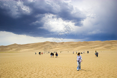 人们在沙丘中行走爬坡蓝色干旱孩子旅行航程女士国家远足荒野图片
