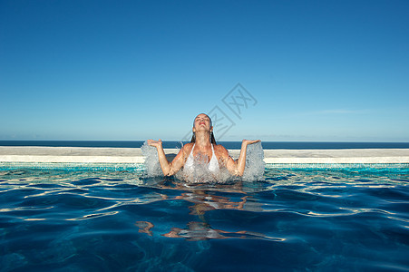 女人在游泳池里放松温泉女孩水池游泳女士棕褐色海洋天堂休息享受图片