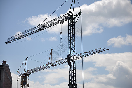 建筑工地上蓝天背景的起重机商业房子脚手架住宅建筑物摩天大楼生长框架工作机器图片