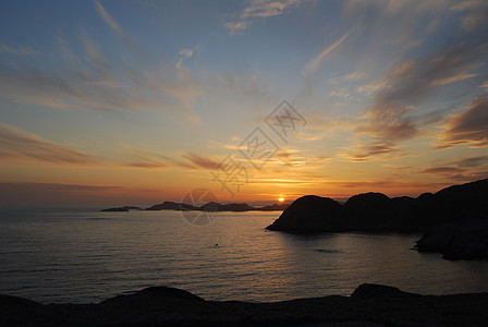 日落太阳橙子椴树红色悬崖阳光天空海岸波浪水平图片