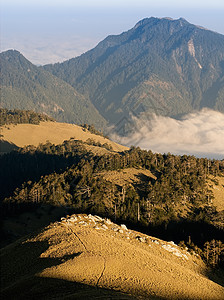 日落的美丽高山和金色草原公园晴天阳光天空蓝色森林农村场地地平线风景图片