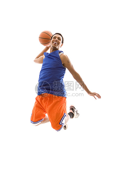 微笑的篮球运动员在空中跳跃 膝弯曲图片