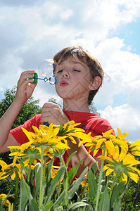 男孩和肥皂泡泡气泡乐趣花朵飞行头巾蓝色阳光游戏衣服快乐图片