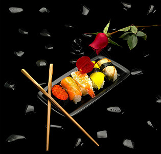 黑背景黑色石块上的各类寿司板图片