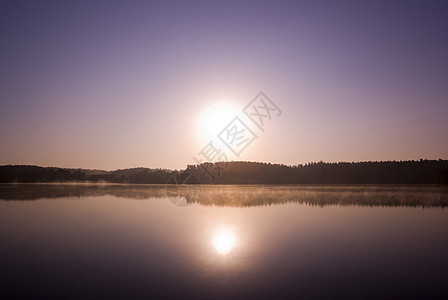 太阳升起天空海岸线日落蓝色场景反射海岸地平线薄雾风景图片