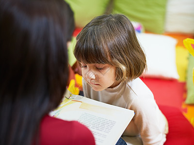 女教师为女童阅读书读物孩子好奇心成人女孩们享受闲暇孩子们专注女性阅读图片