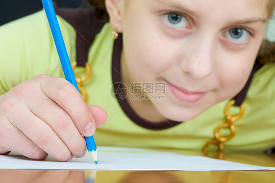 女孩拿着蓝铅笔照片叶子微笑绘画水平女学生桌子写字桌绿色棕色图片