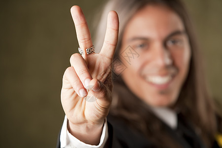 身穿正装的帅哥在做一个和平标志快乐手指补丁男性领带头发戒指手势夹克原住民图片