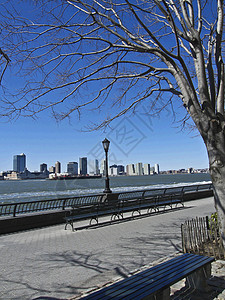 坐在哈德逊河边天空反射都市黑色城市阳光球衣景观旅行建筑学图片