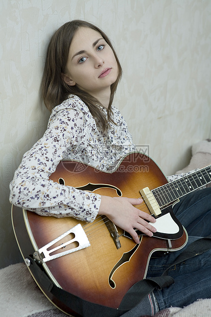 玩吉他迷人的年轻女子图片