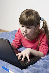 玩电脑的可爱小姑娘乐趣游戏学习者爱好学习孩子享受帮助网络笔记本图片